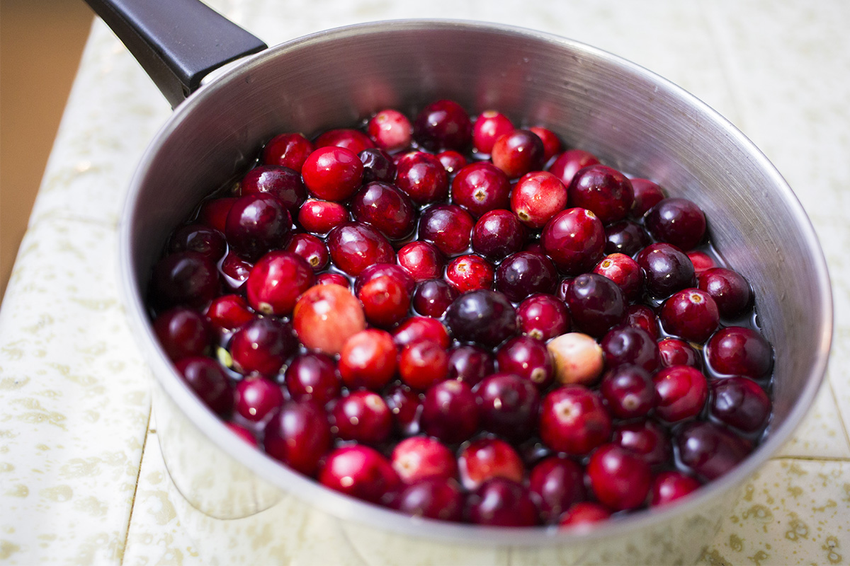 Rinsing cranberries in a pot.