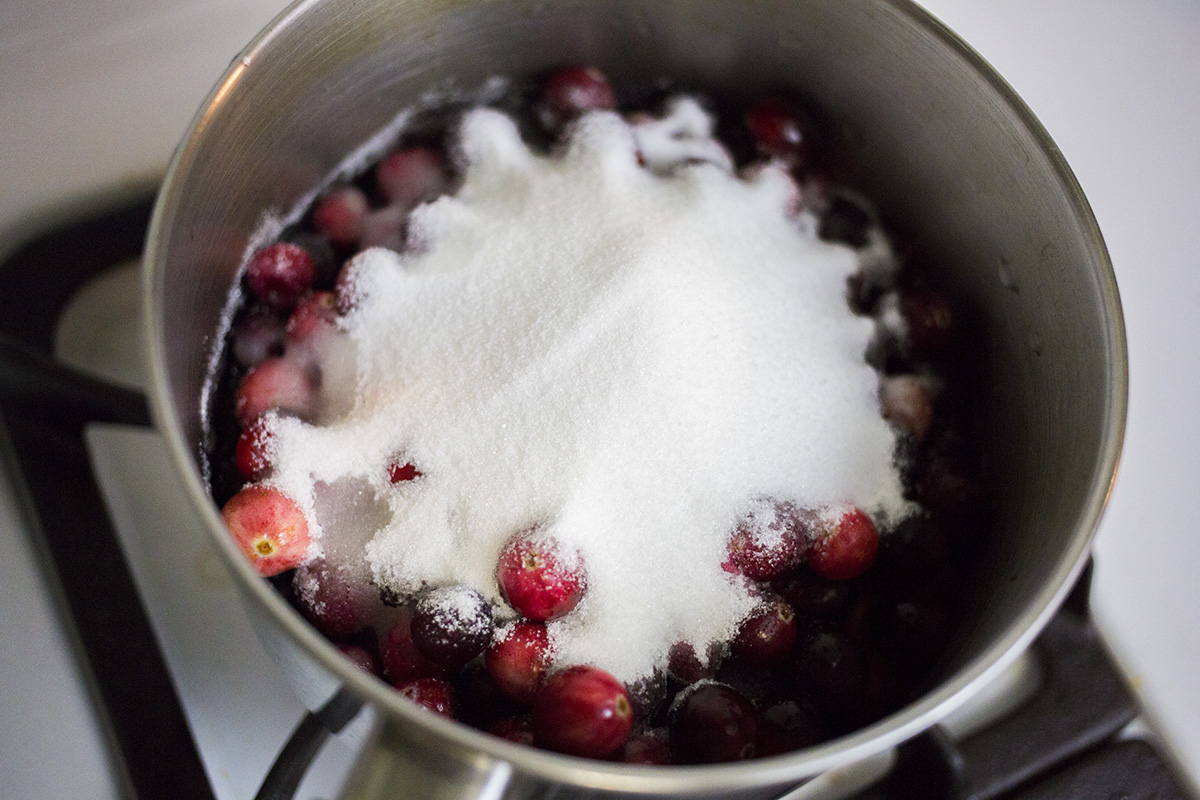 Adding sugar and water to cranberries.