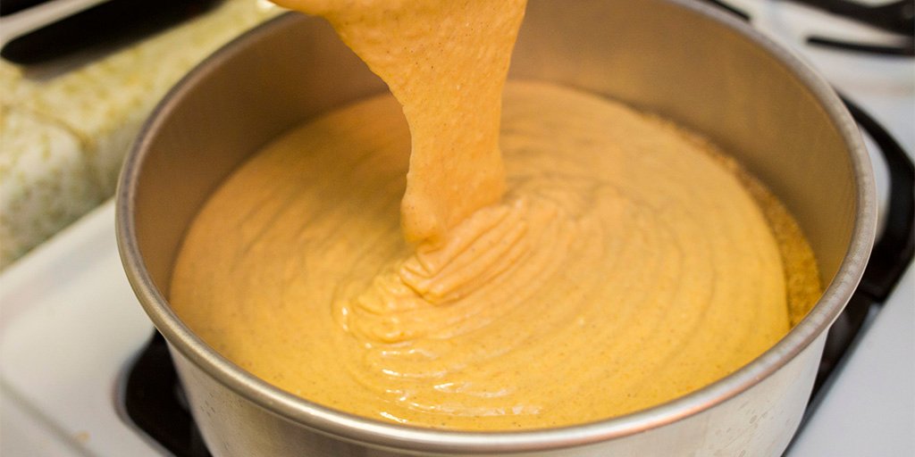 Pouring pumpkin mixture into a cake pan.